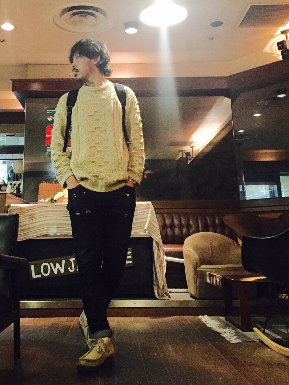 ブラック系のバックパック/リュック、ホワイト系のニット/セーター、ブラック系のデニムパンツを着用したメンズの秋コーディネートの1枚目の写真