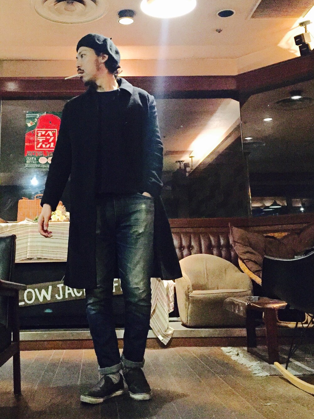 ブラック系のステンカラーコート、ブルー系のニット/セーター、ブルー系のデニムパンツを着用したメンズの冬コーディネートの1枚目の写真