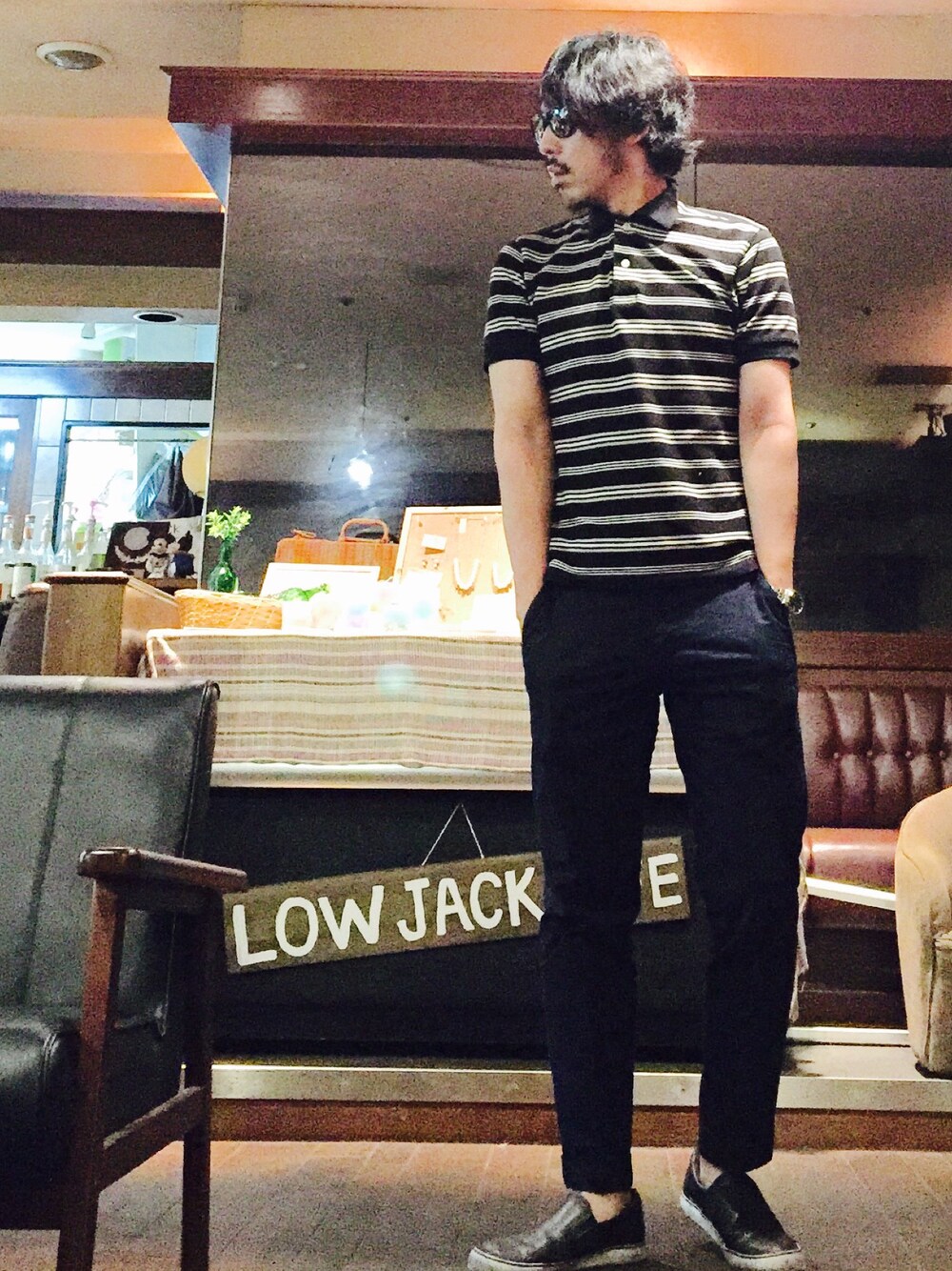 ブラック系のポロシャツ、ブラック系のスニーカー、ブルー系のスラックスを着用したメンズの春コーディネートの1枚目の写真