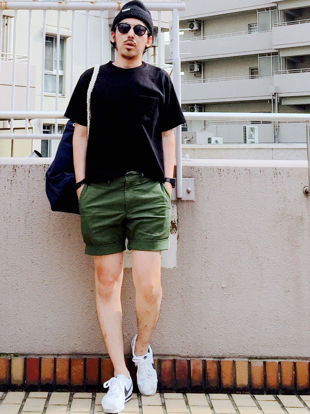 ブルー系のバックパック/リュック、グリーン系のその他パンツ、ホワイト系のスニーカーを着用したメンズの夏コーディネートの1枚目の写真