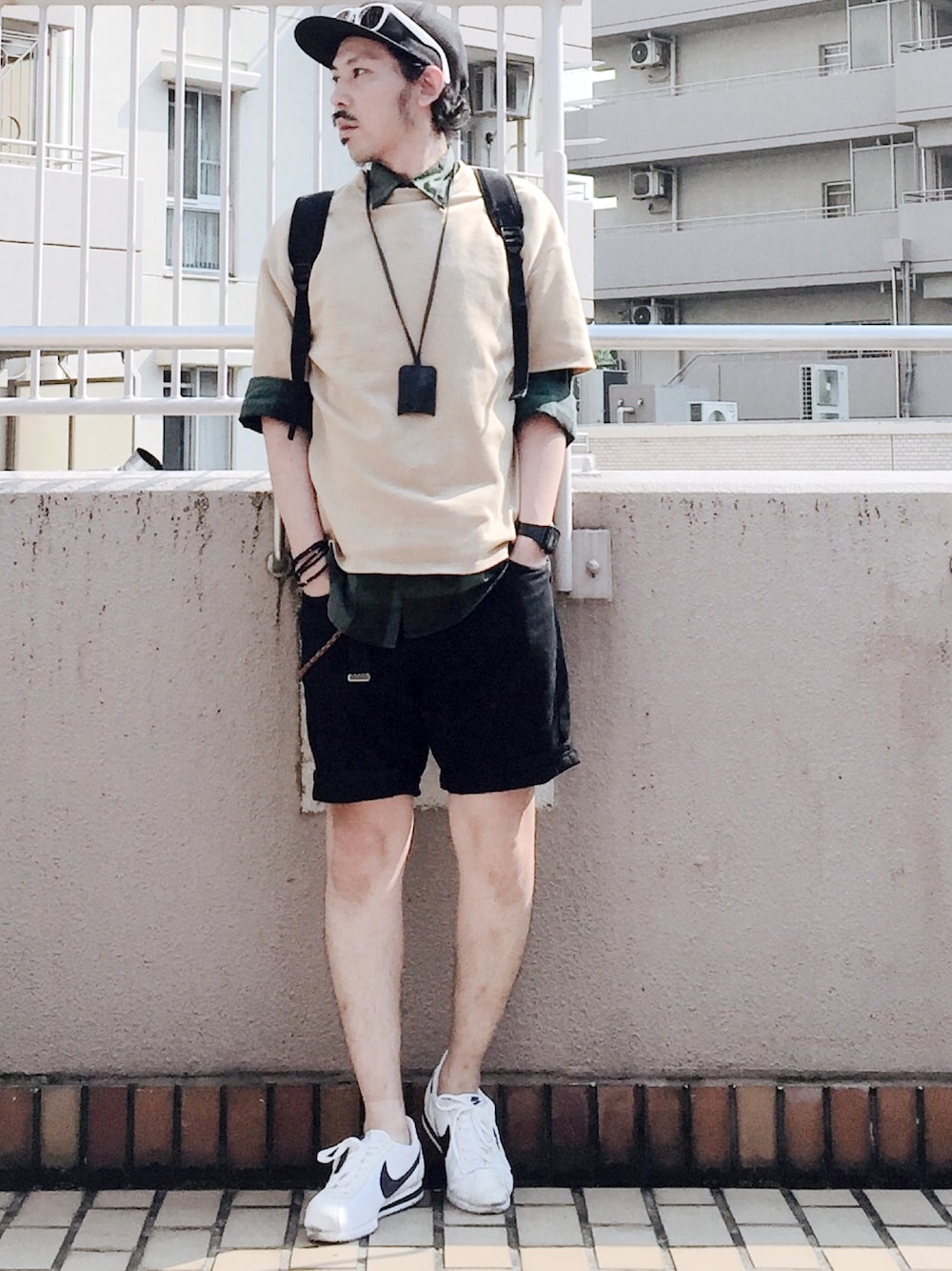 ベージュ系のTシャツ/カットソー、ブラック系のデニムパンツ、ホワイト系のスニーカーを着用したメンズの夏コーディネートの1枚目の写真