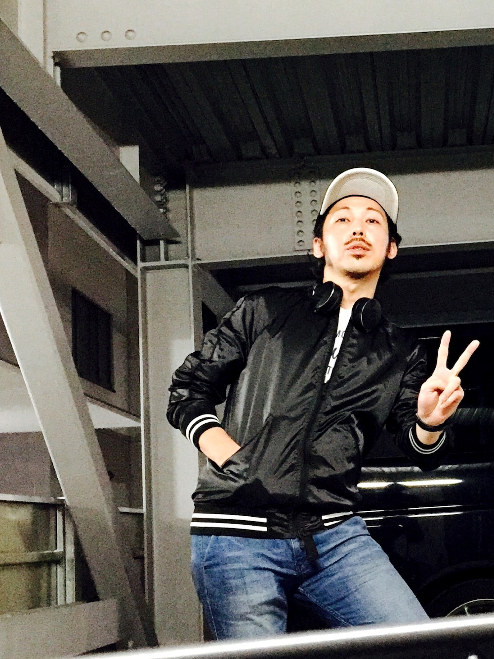 ブラック系のブルゾン、ホワイト系のTシャツ/カットソー、ブルー系のデニムパンツを着用したメンズの秋コーディネートの1枚目の写真