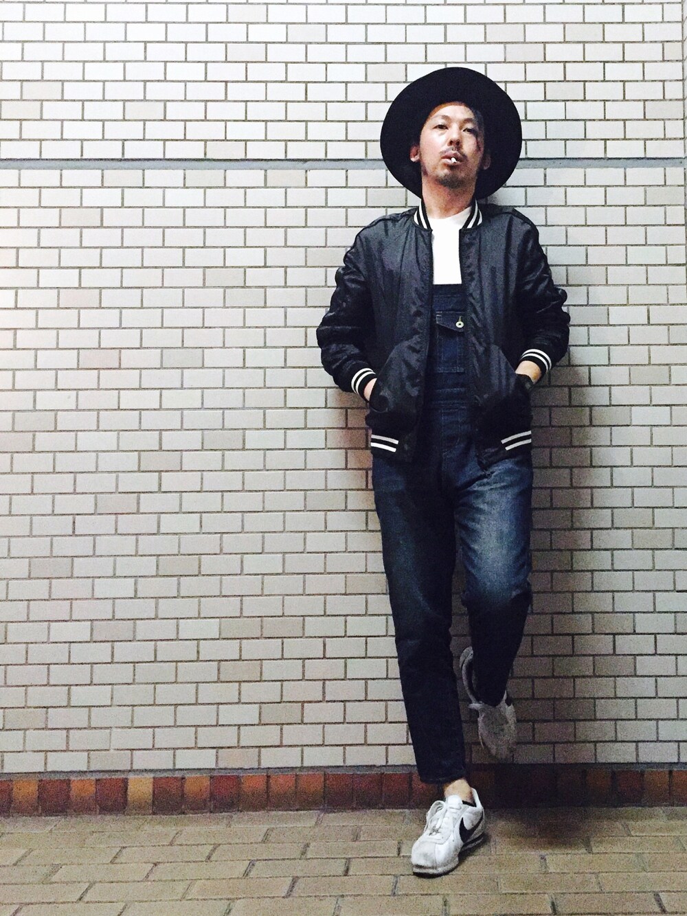 ブラック系のブルゾン、ブルー系のサロペット/オーバーオール、ホワイト系のTシャツ/カットソーを着用したメンズの秋コーディネートの1枚目の写真