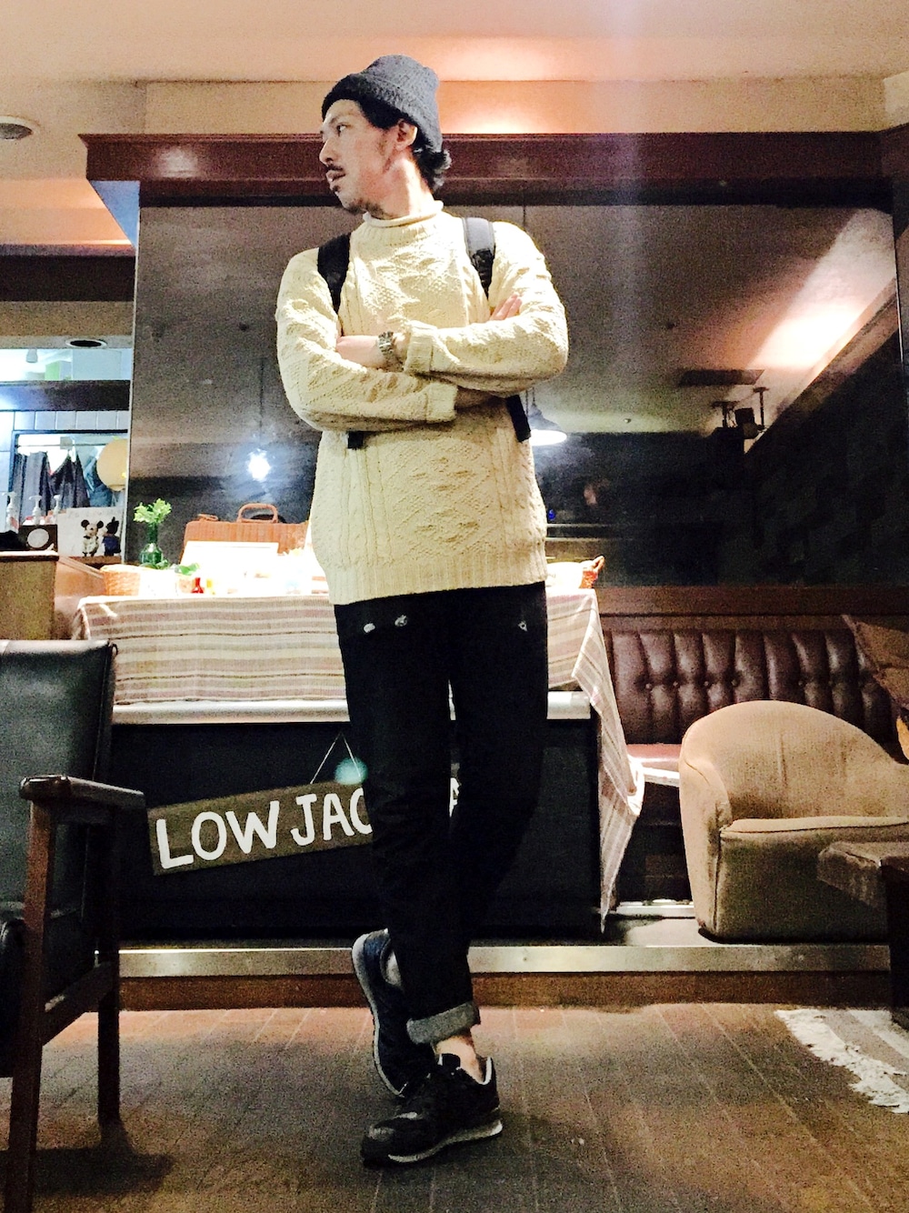 ホワイト系のニット/セーター、ブラック系のスニーカー、ブラック系のデニムパンツを着用したメンズの秋コーディネートの1枚目の写真