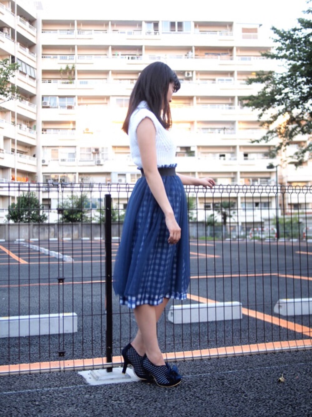 ブルー系のスカート、ブルー系のブーティ、ホワイト系のニット/セーターを着用したレディースの夏コーディネートの1枚目の写真