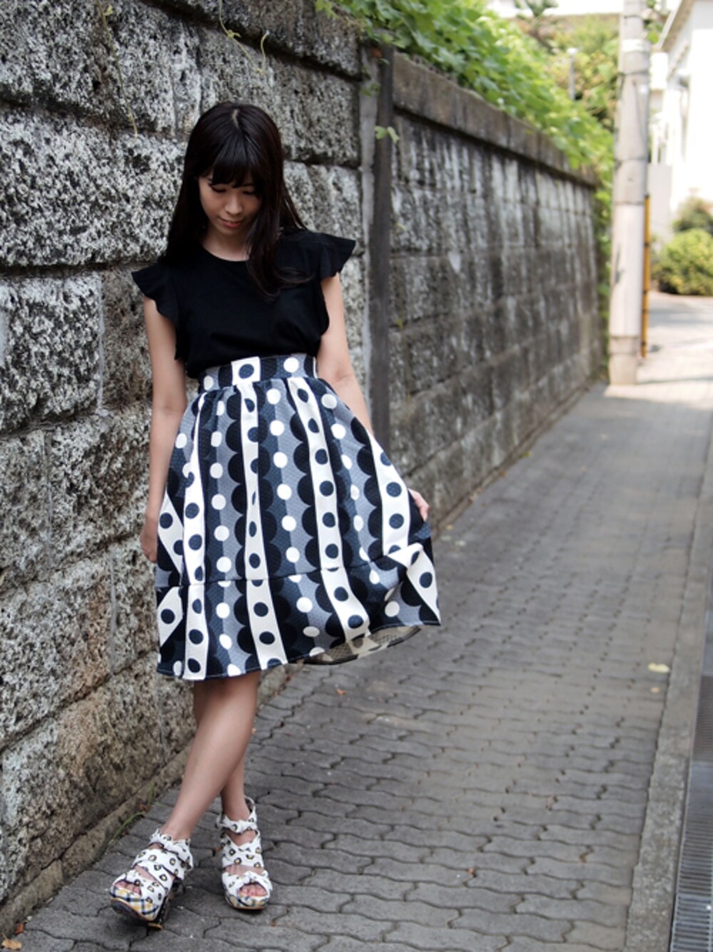 ブラック系のTシャツ/カットソー、ブラック系のスカート、その他のサンダルを着用したレディースの夏コーディネートの1枚目の写真