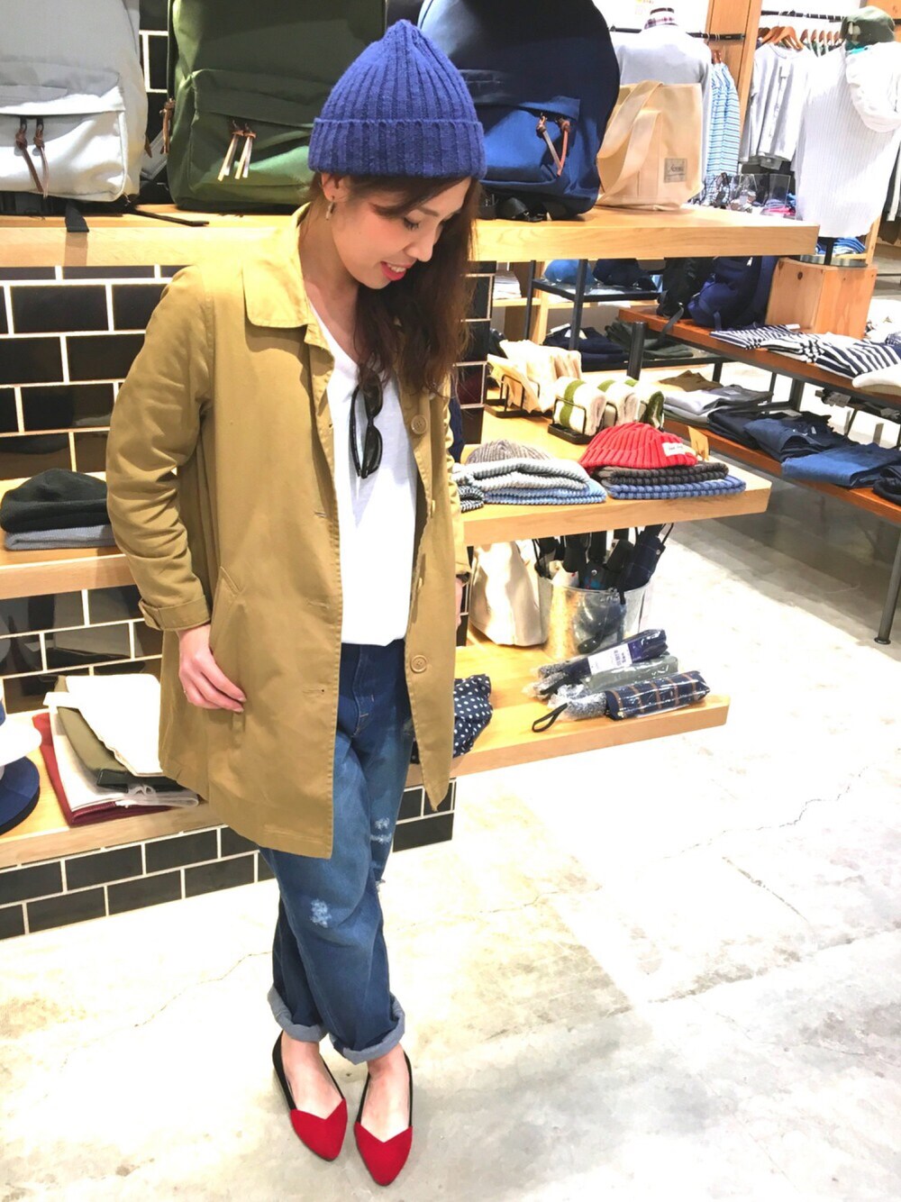 ベージュ系のステンカラーコート、ブルー系のデニムパンツ、ホワイト系のTシャツ/カットソーを着用したレディースの春コーディネートの1枚目の写真