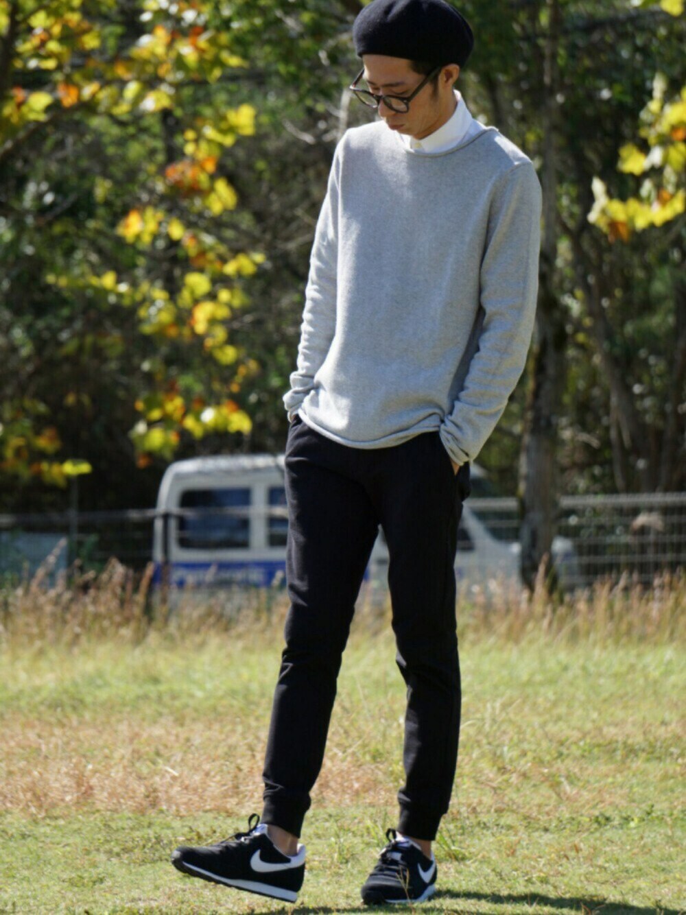 ブラック系のスニーカー、ブラック系のチノパンツ、グレー系のニット/セーターを着用したメンズの秋コーディネートの1枚目の写真