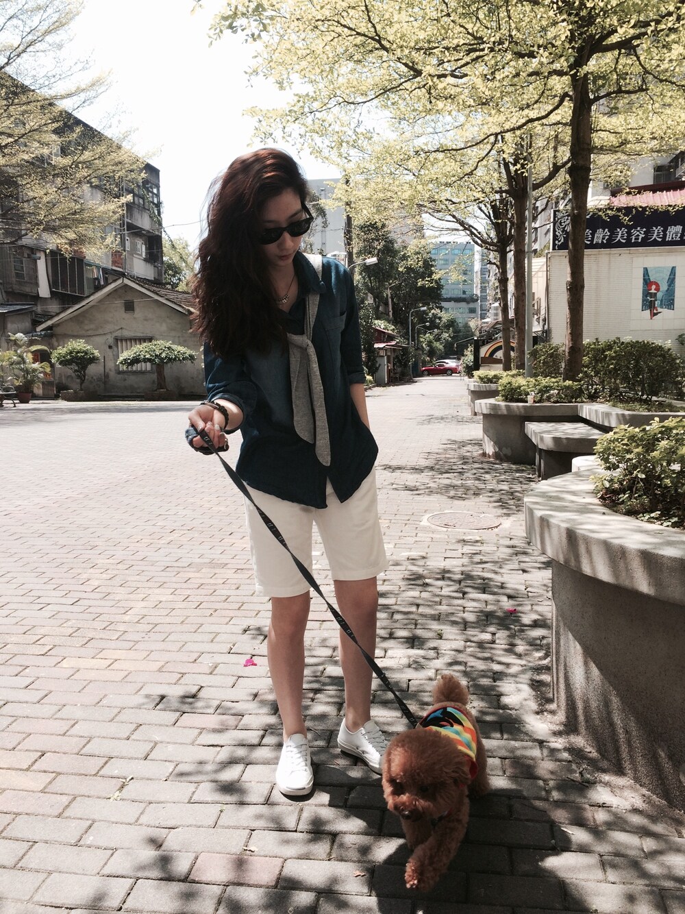 ブルー系のデニムジャケット、ホワイト系のカーゴパンツ、ホワイト系のスニーカーを着用したレディースの春コーディネートの1枚目の写真