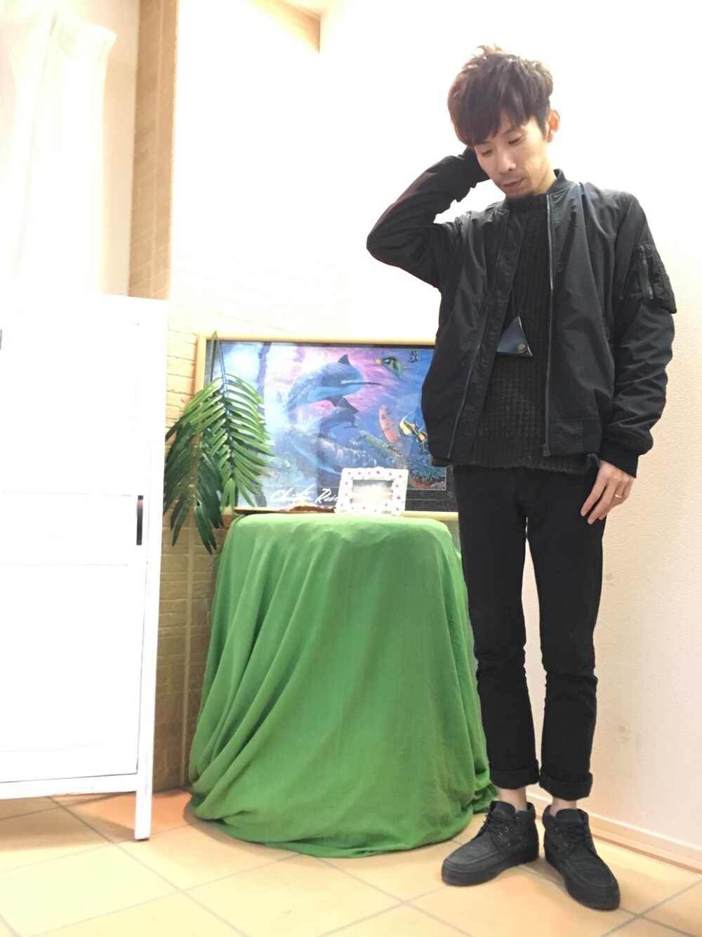 ブラック系のパンツ、ブラック系のMA-1、グリーン系のニット/セーターを着用したメンズの冬コーディネートの1枚目の写真