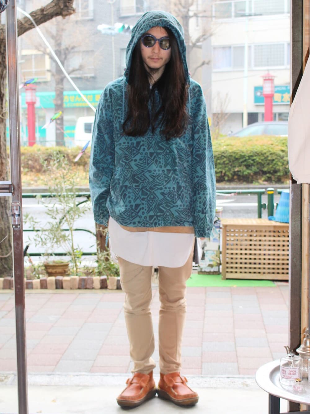 グリーン系のパーカー、ベージュ系のその他パンツ、ブラウン系のブーツを着用したメンズの冬コーディネートの1枚目の写真