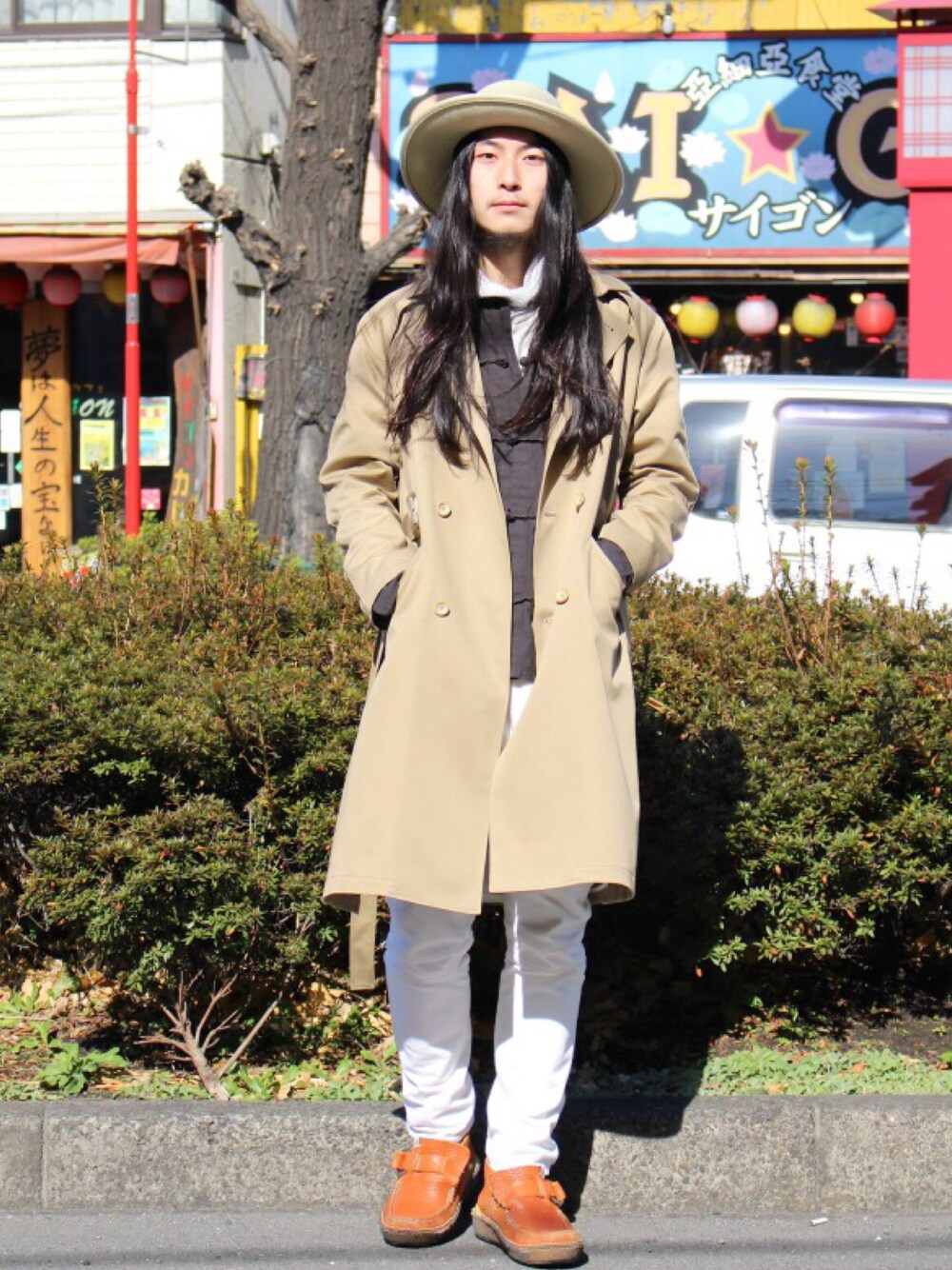 ベージュ系のトレンチコート、ホワイト系のデニムパンツ、ブラウン系のブーツを着用したメンズの冬コーディネートの1枚目の写真