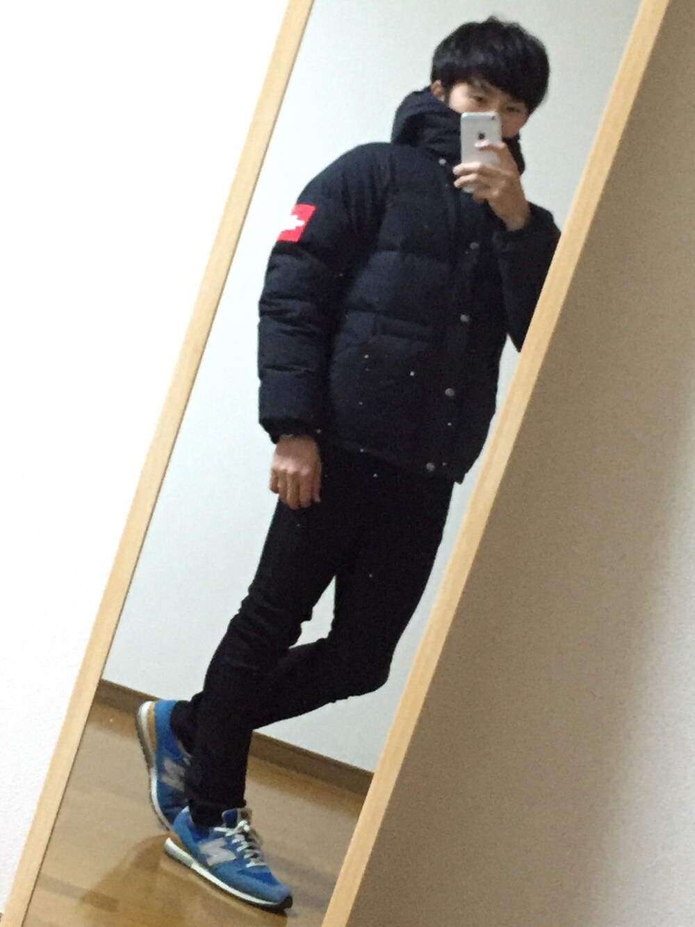 ブラック系のダウンジャケット/コート、ブラック系のデニムパンツ、ブルー系のスニーカーを着用したメンズの冬コーディネートの1枚目の写真