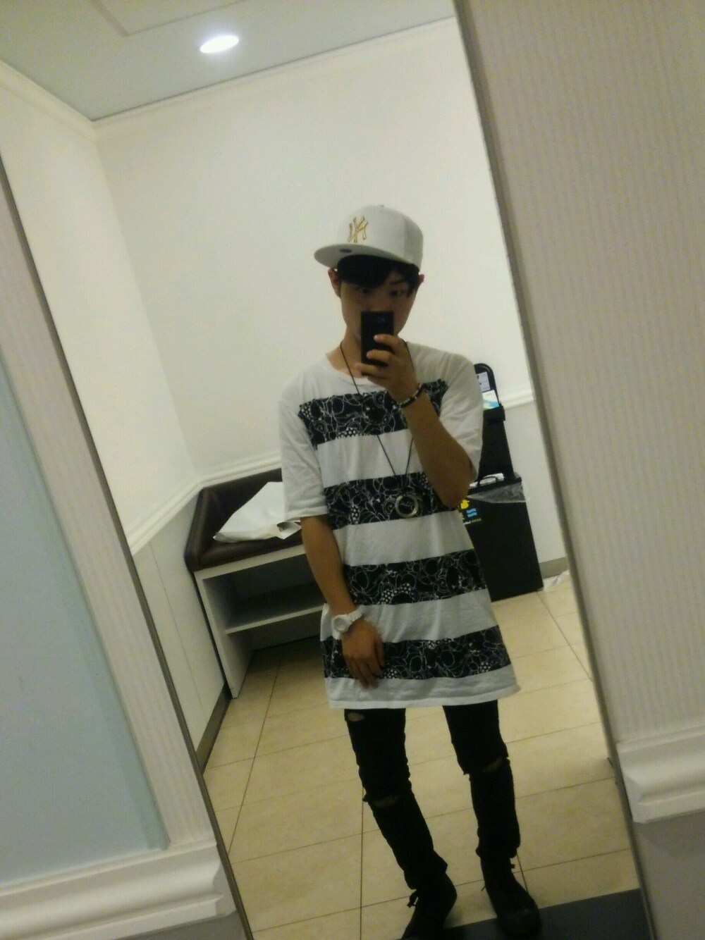 ブラック系のトップス、ブラック系のパンツ、ホワイト系の帽子を着用したメンズの夏コーディネートの1枚目の写真