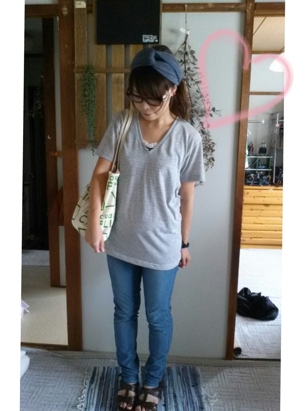 グレー系のTシャツ/カットソー、グリーン系のエコバッグ/サブバッグ、ブラウン系のサンダルを着用したレディースの夏コーディネートの1枚目の写真