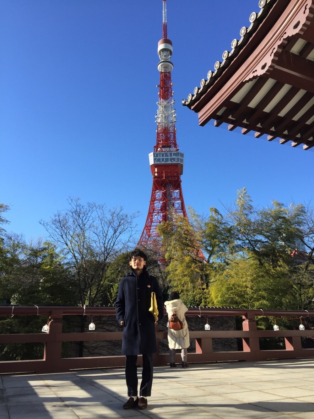 ブルー系のピーコート、グレー系のスウェット、ブルー系のスラックスを着用したメンズの冬コーディネートの1枚目の写真