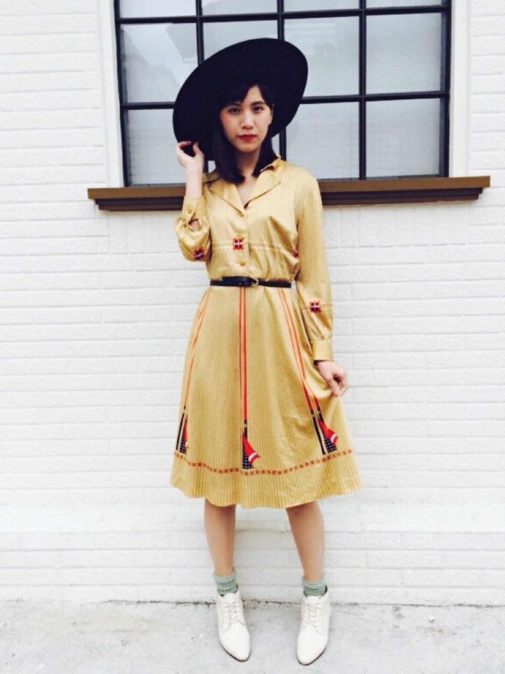 ゴールド系のワンピースを着用したレディースの冬コーディネートの1枚目の写真