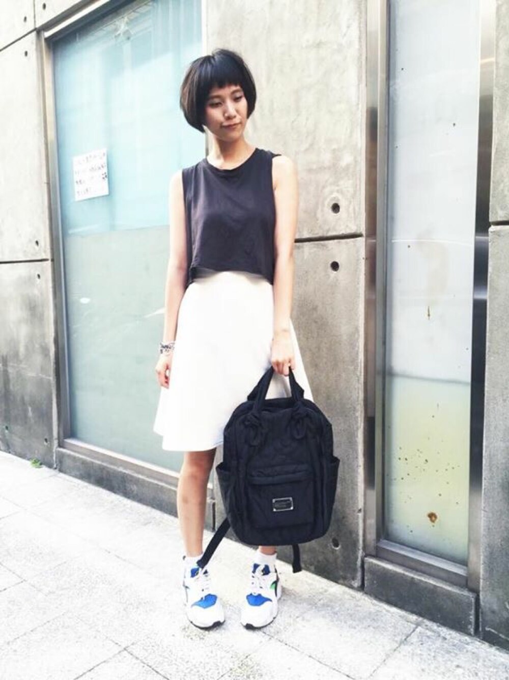 ブラック系のバックパック/リュック、ホワイト系のスニーカーを着用したレディースの夏コーディネートの1枚目の写真