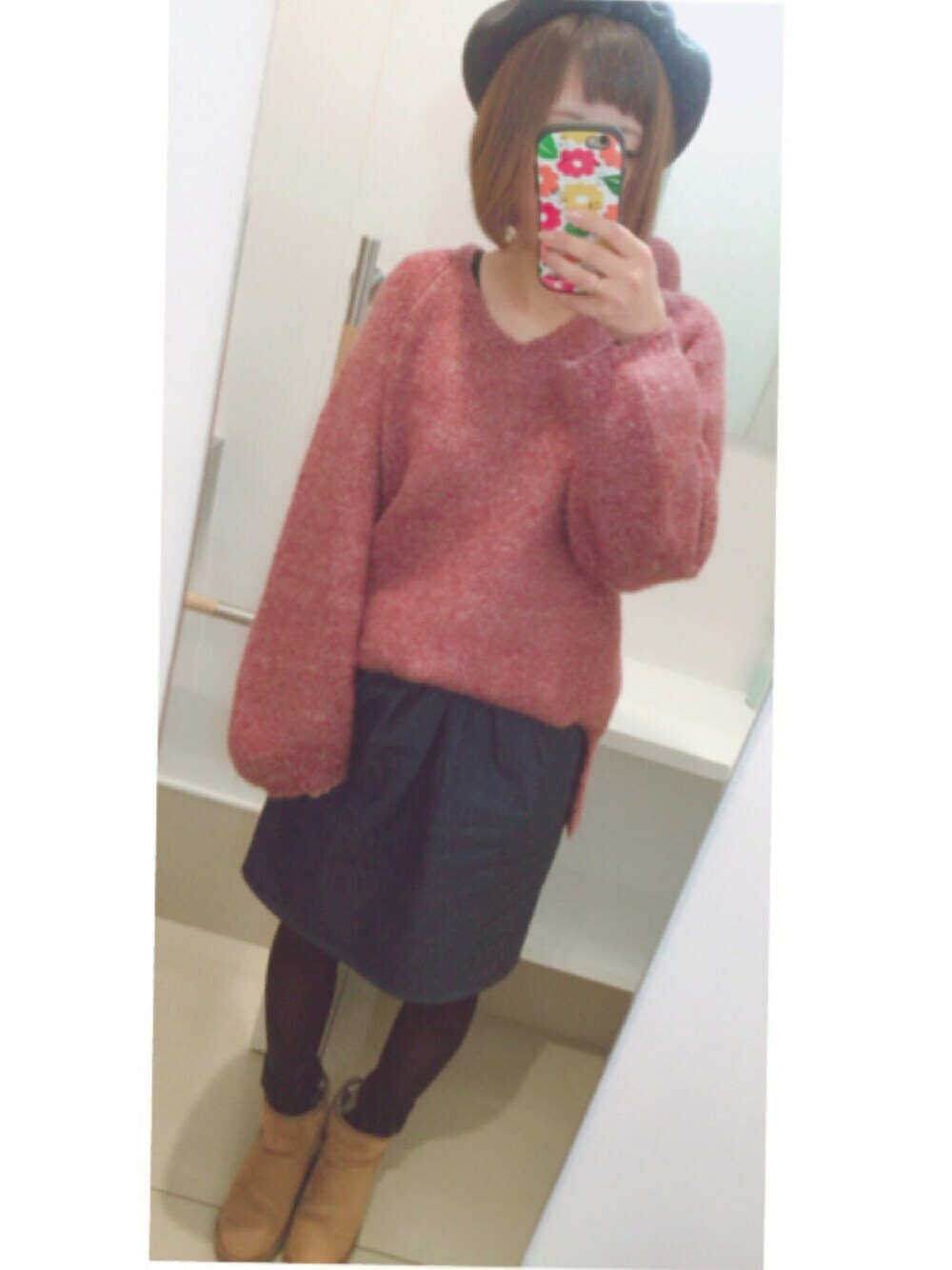 レッド系のニット/セーター、ブルー系のデニムスカート、ベージュ系のブーツを着用したレディースの冬コーディネートの1枚目の写真