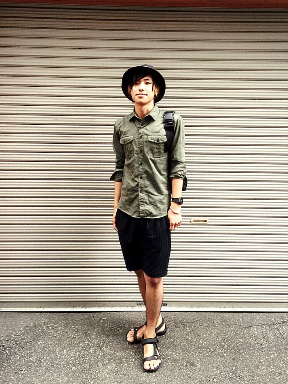 ブラック系のボディバッグ/ウエストポーチ、グリーン系のシャツ/ブラウス、ブラック系のスラックスを着用したメンズの夏コーディネートの1枚目の写真