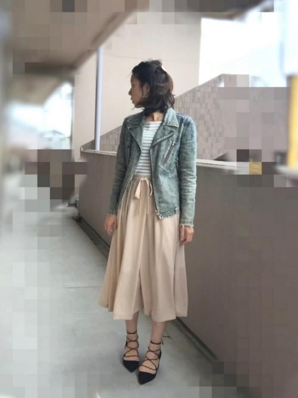 ベージュ系のスカート、グレー系のライダースジャケット、ブラック系のパンプスを着用したレディースの春コーディネートの1枚目の写真