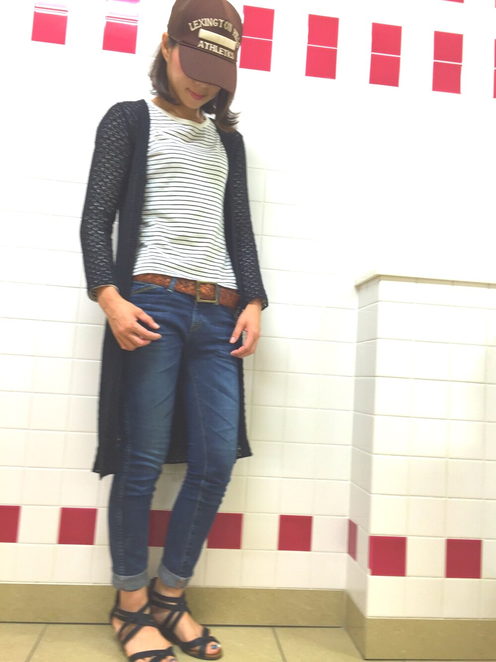 ブルー系のデニムパンツ、ホワイト系のTシャツ/カットソー、ブラウン系のキャップを着用したレディースの春コーディネートの1枚目の写真