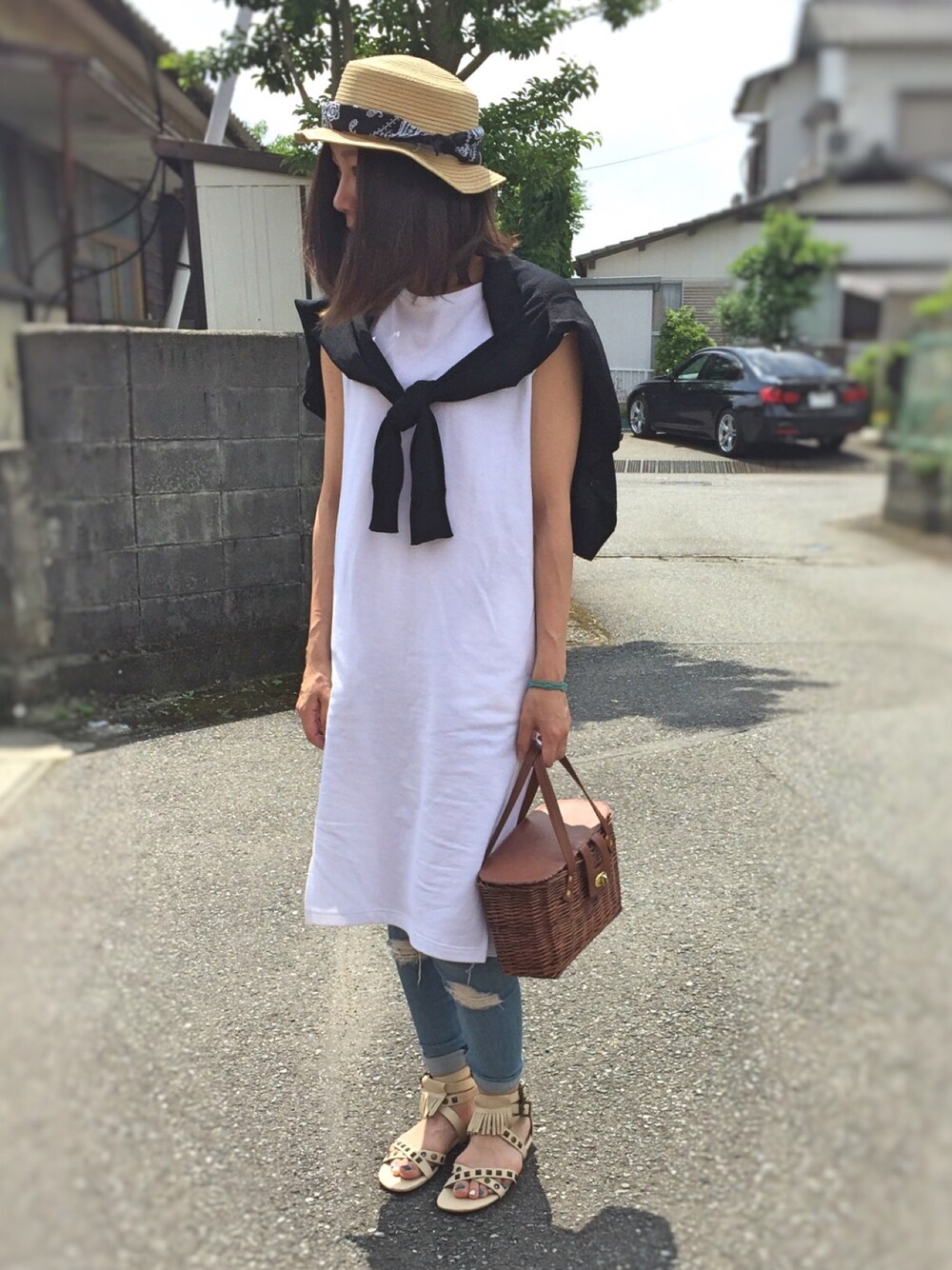 ホワイト系のTシャツ/カットソー、ブラウン系のかごバッグ、ベージュ系のサンダルを着用したレディースの春コーディネートの1枚目の写真