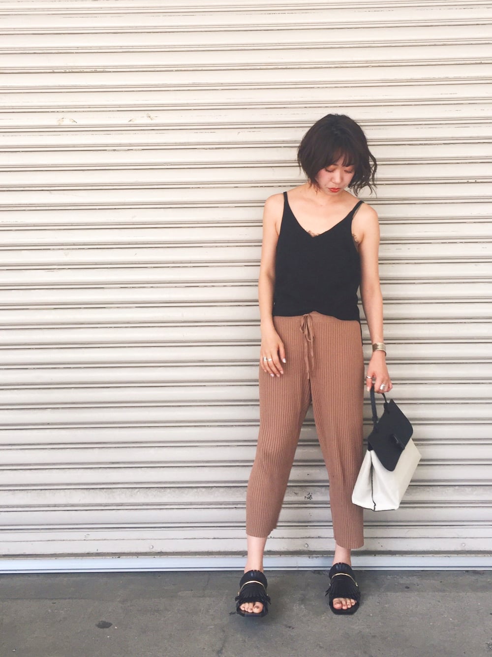 ブラック系のキャミソール、ブラック系のトートバッグ、イエロー系のその他パンツを着用したレディースの春コーディネートの1枚目の写真