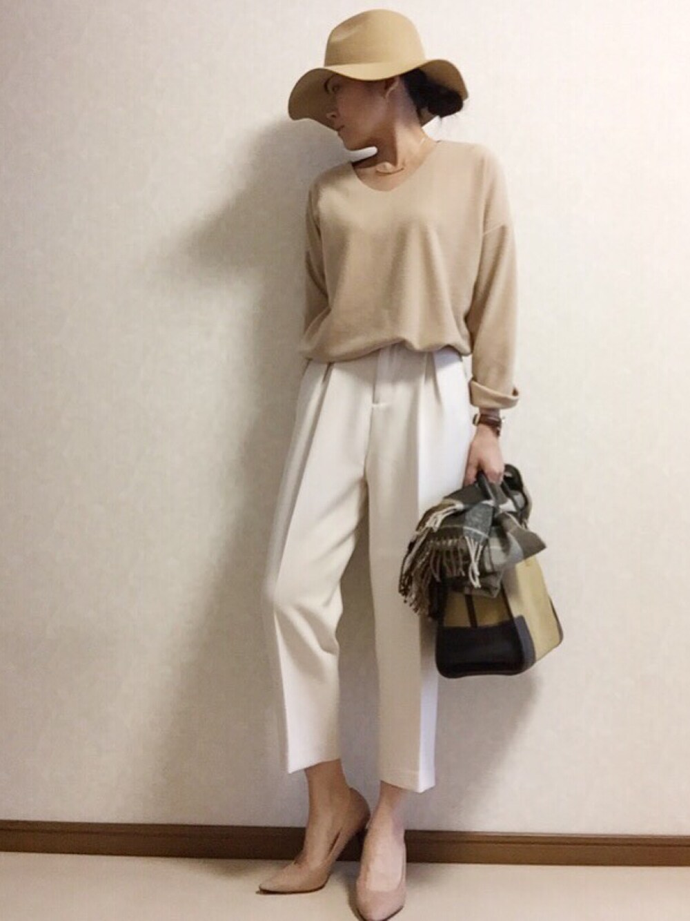 ベージュ系のニット/セーター、ホワイト系のその他パンツ、ベージュ系のハンドバッグを着用したレディースの冬コーディネートの1枚目の写真