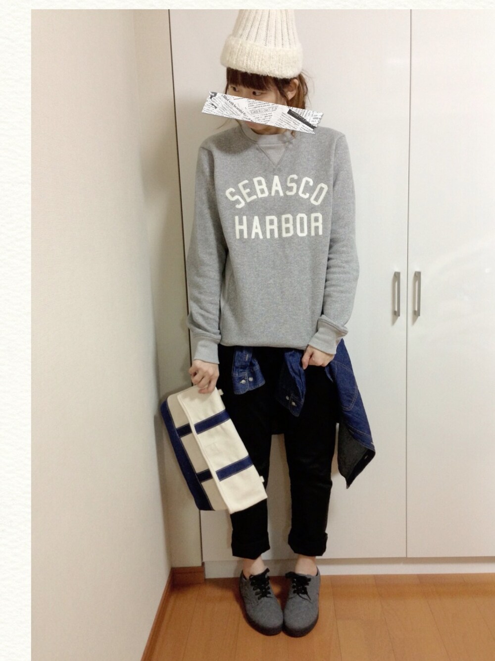 ホワイト系のクラッチバッグ、グレー系のスウェット、グレー系のスニーカーを着用したレディースの冬コーディネートの1枚目の写真