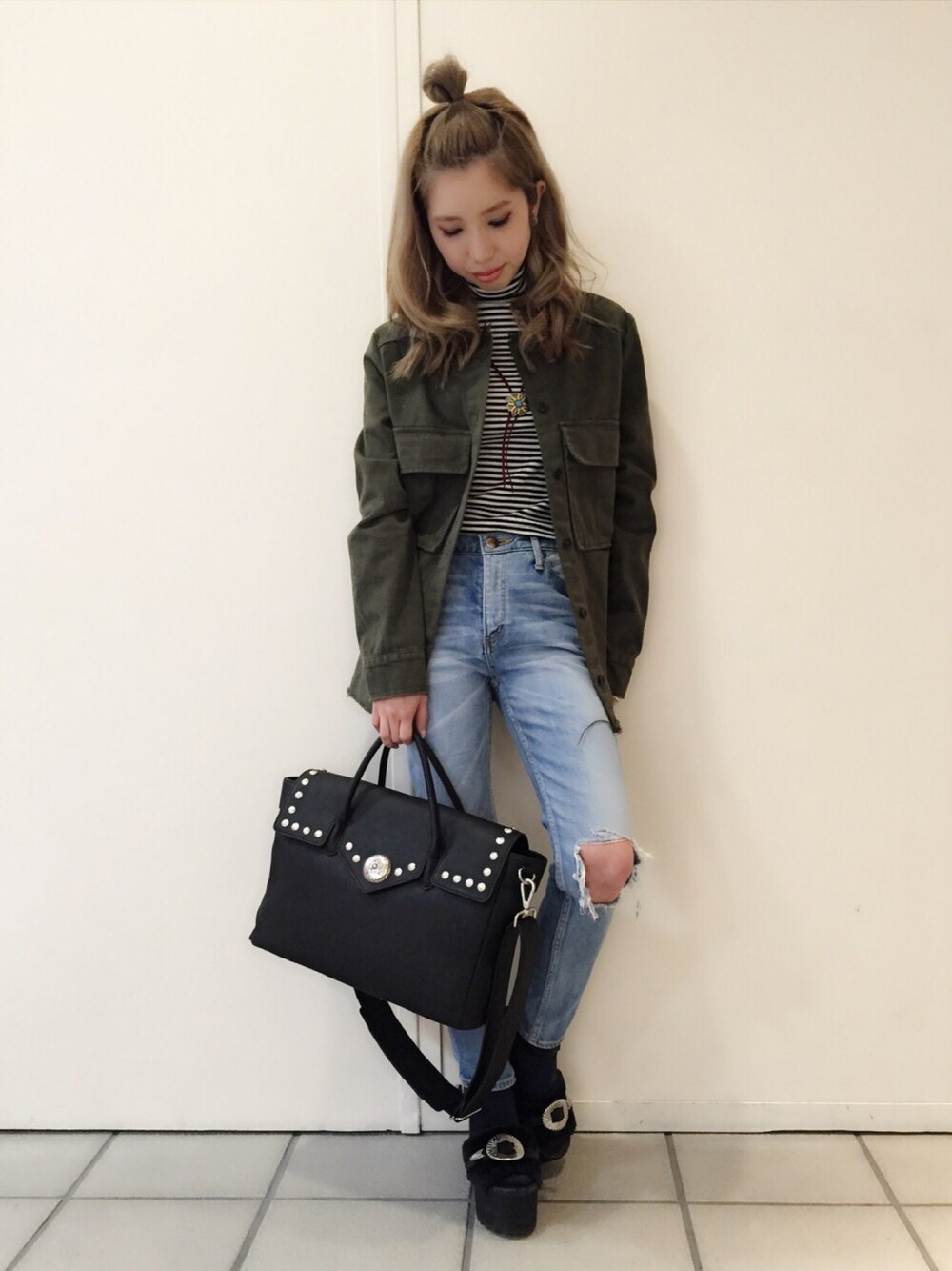 グリーン系のデニムジャケット、ブラック系のトートバッグ、ブラック系のサンダルを着用したレディースの冬コーディネートの1枚目の写真
