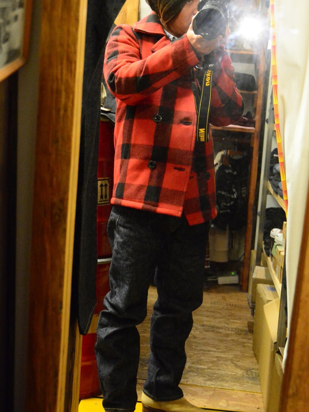 レッド系のピーコート、ブルー系のシャツ/ブラウス、ブルー系のデニムパンツを着用したメンズの冬コーディネートの1枚目の写真