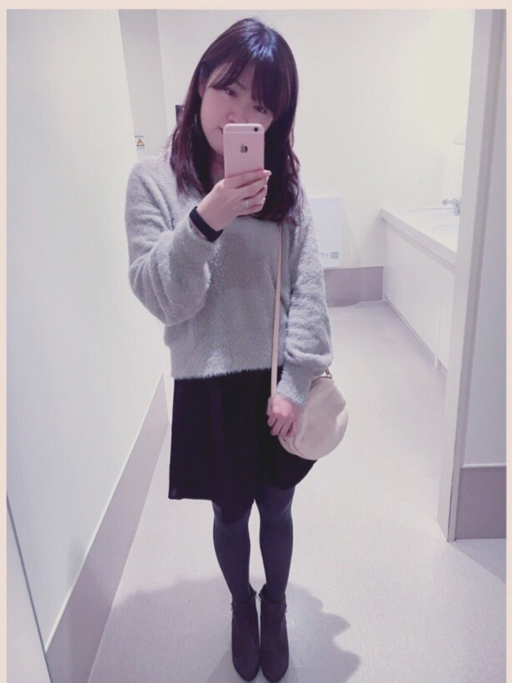 ベージュ系のニット/セーター、ブラック系のスカート、グレー系のブーツを着用したレディースの秋コーディネートの1枚目の写真