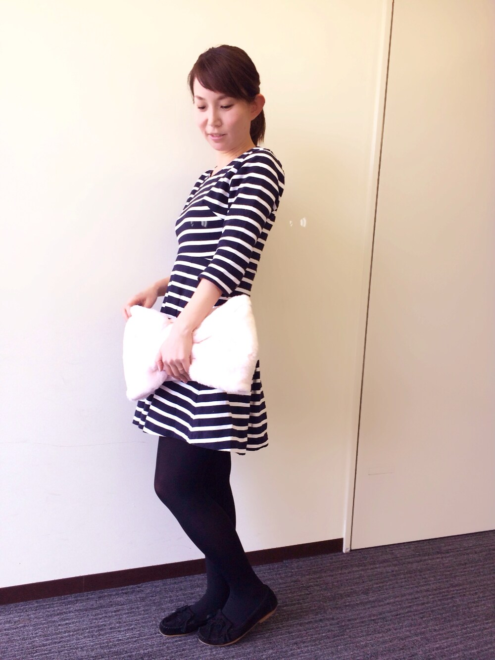 ブルー系のワンピース、ピンク系のクラッチバッグを着用したレディースの春コーディネートの1枚目の写真