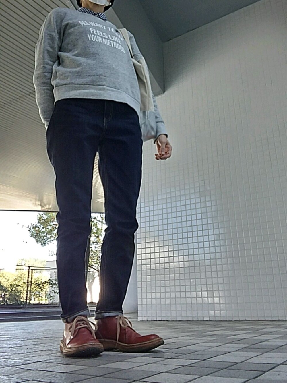 ブルー系のデニムパンツ、グレー系のスウェット、ブラウン系のブーツを着用したレディースの秋コーディネートの1枚目の写真