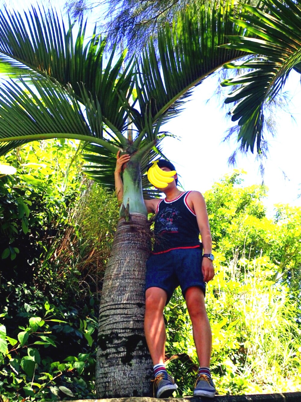 ブラック系のタンクトップ、ブルー系のチノパンツ、グリーン系のその他を着用したメンズの夏コーディネートの1枚目の写真