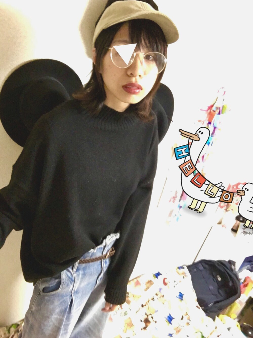 ブラック系のニット/セーター、ブルー系のデニムパンツ、ベージュ系のキャップを着用したレディースの秋コーディネートの1枚目の写真