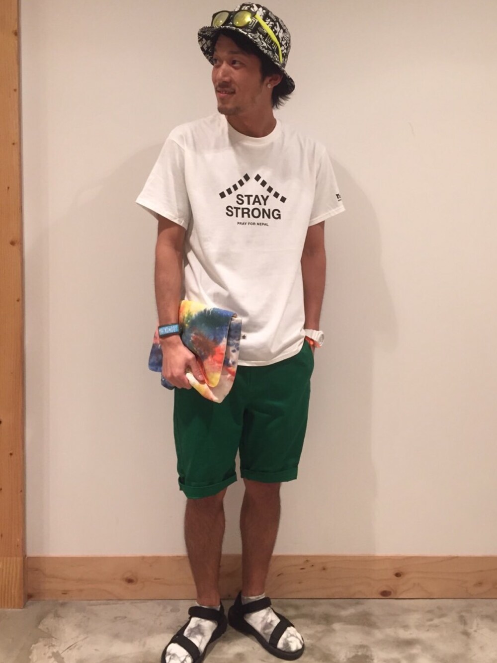 ホワイト系のTシャツ/カットソー、グリーン系のチノパンツ、ブラック系のサンダルを着用したメンズの夏コーディネートの1枚目の写真