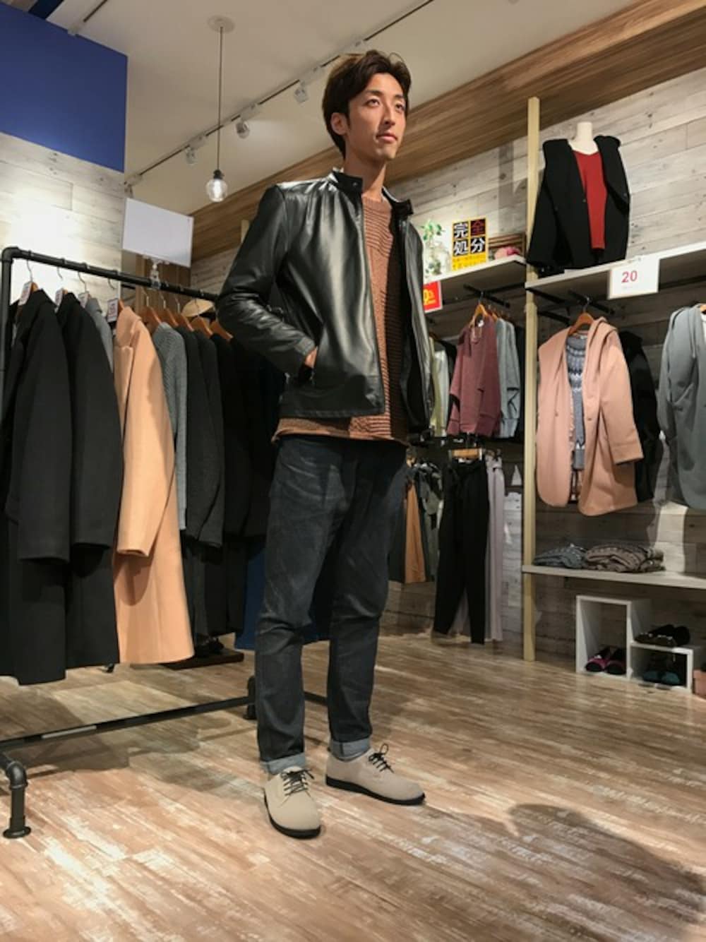 ブルー系のデニムパンツ、ブラウン系のニット/セーター、ブラック系のライダースジャケットを着用したメンズの秋コーディネートの1枚目の写真