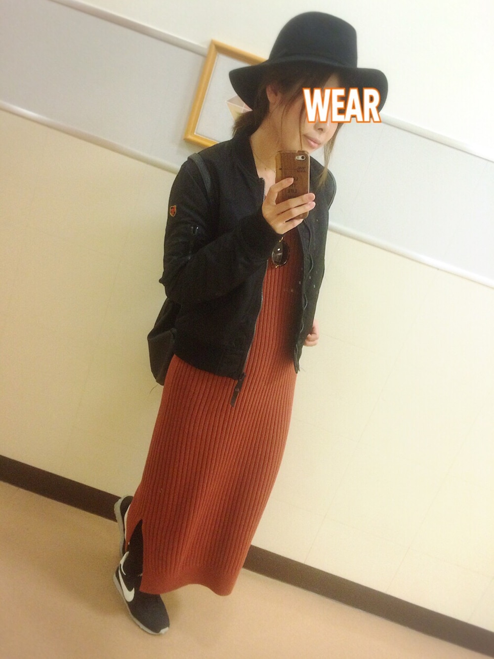 ブラック系のジャケット/アウター、レッド系のワンピース、ブラック系のスニーカーを着用したレディースの秋コーディネートの1枚目の写真