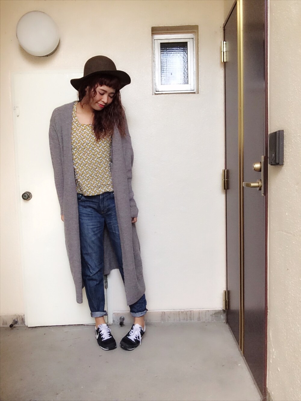 グレー系のカーディガン/ボレロ、イエロー系のトップス、ブルー系のデニムパンツを着用したレディースの秋コーディネートの1枚目の写真