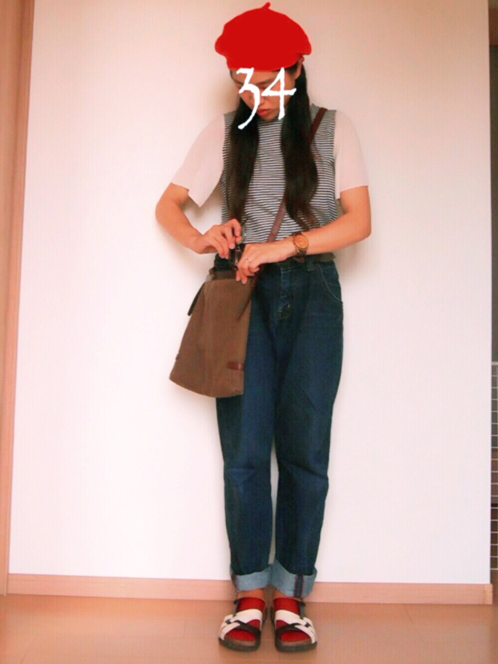 ブルー系のデニムパンツ、ブラック系のTシャツ/カットソー、ブラウン系のショルダーバッグを着用したレディースの夏コーディネートの1枚目の写真