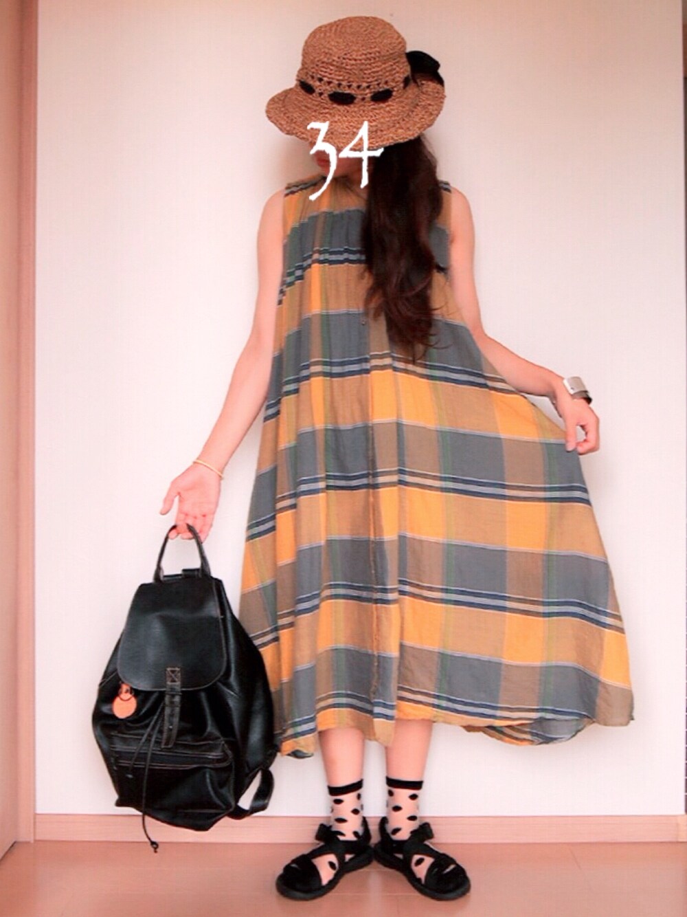 イエロー系のワンピース、ブラック系のサンダル、その他のハットを着用したレディースの夏コーディネートの1枚目の写真