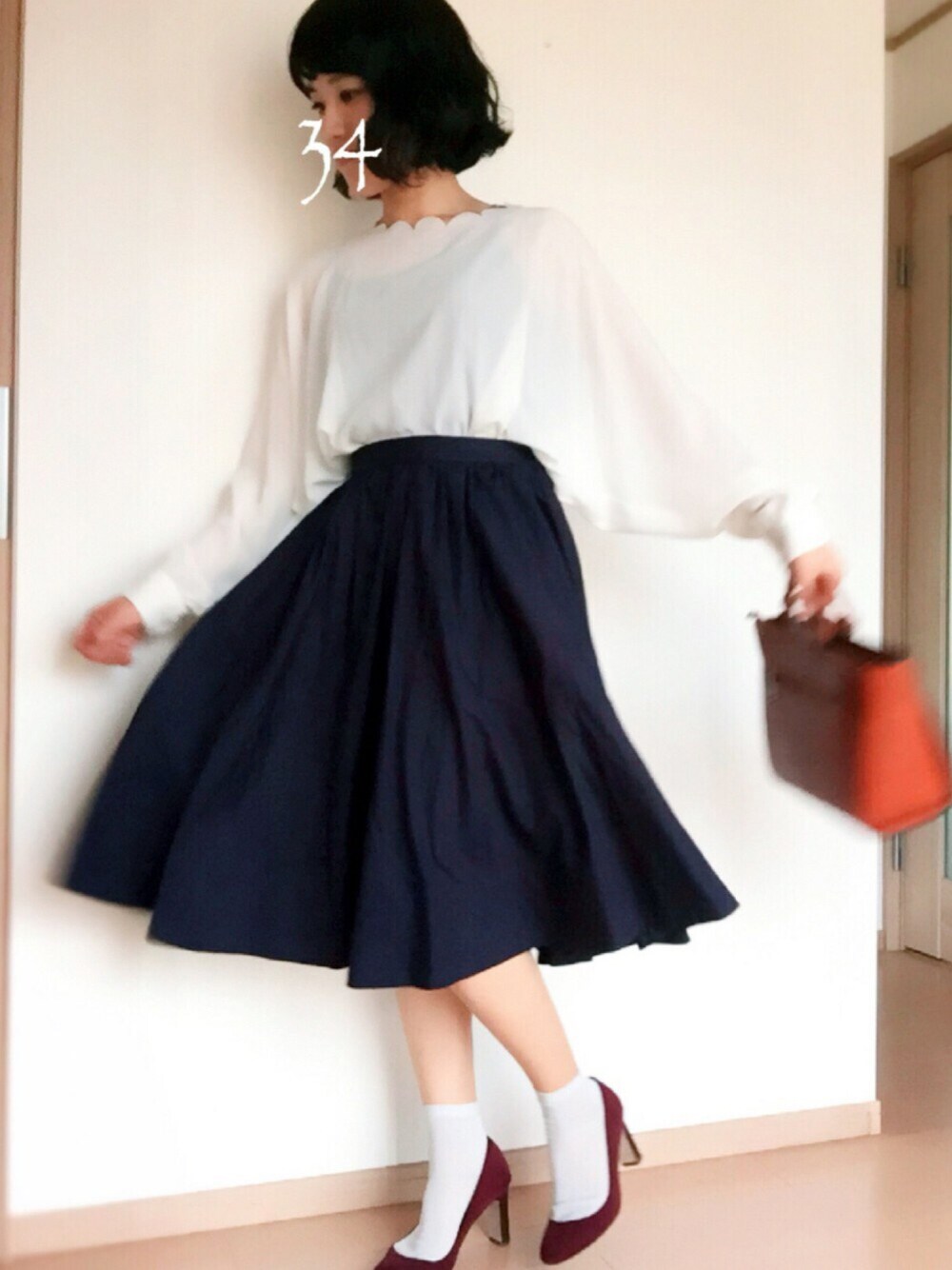 レッド系のパンプス、ブルー系のスカート、ホワイト系のシャツ/ブラウスを着用したレディースの秋コーディネートの1枚目の写真