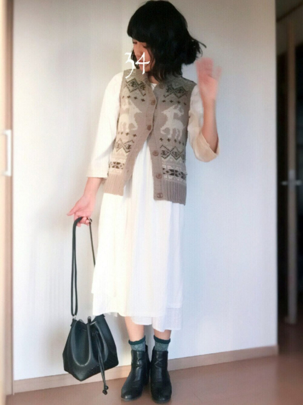 ホワイト系のワンピース、ブラック系のショルダーバッグ、ブラック系のブーティを着用したレディースの秋コーディネートの1枚目の写真