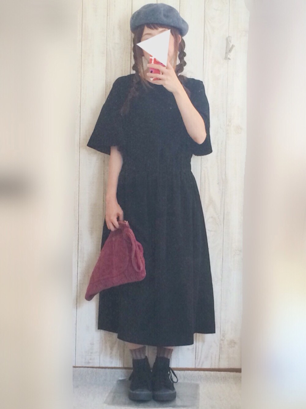 ブラック系のスニーカー、ブラック系のワンピース、ピンク系のクラッチバッグを着用したレディースの秋コーディネートの1枚目の写真