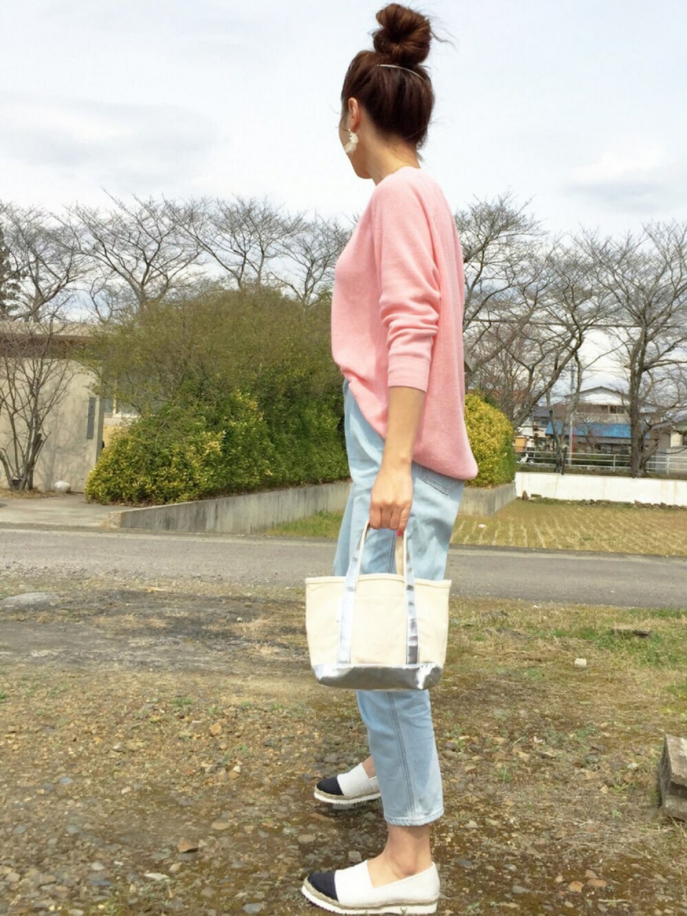 ブルー系のデニムパンツ、シルバー系のハンドバッグ、ホワイト系のその他シューズを着用したレディースの春コーディネートの1枚目の写真