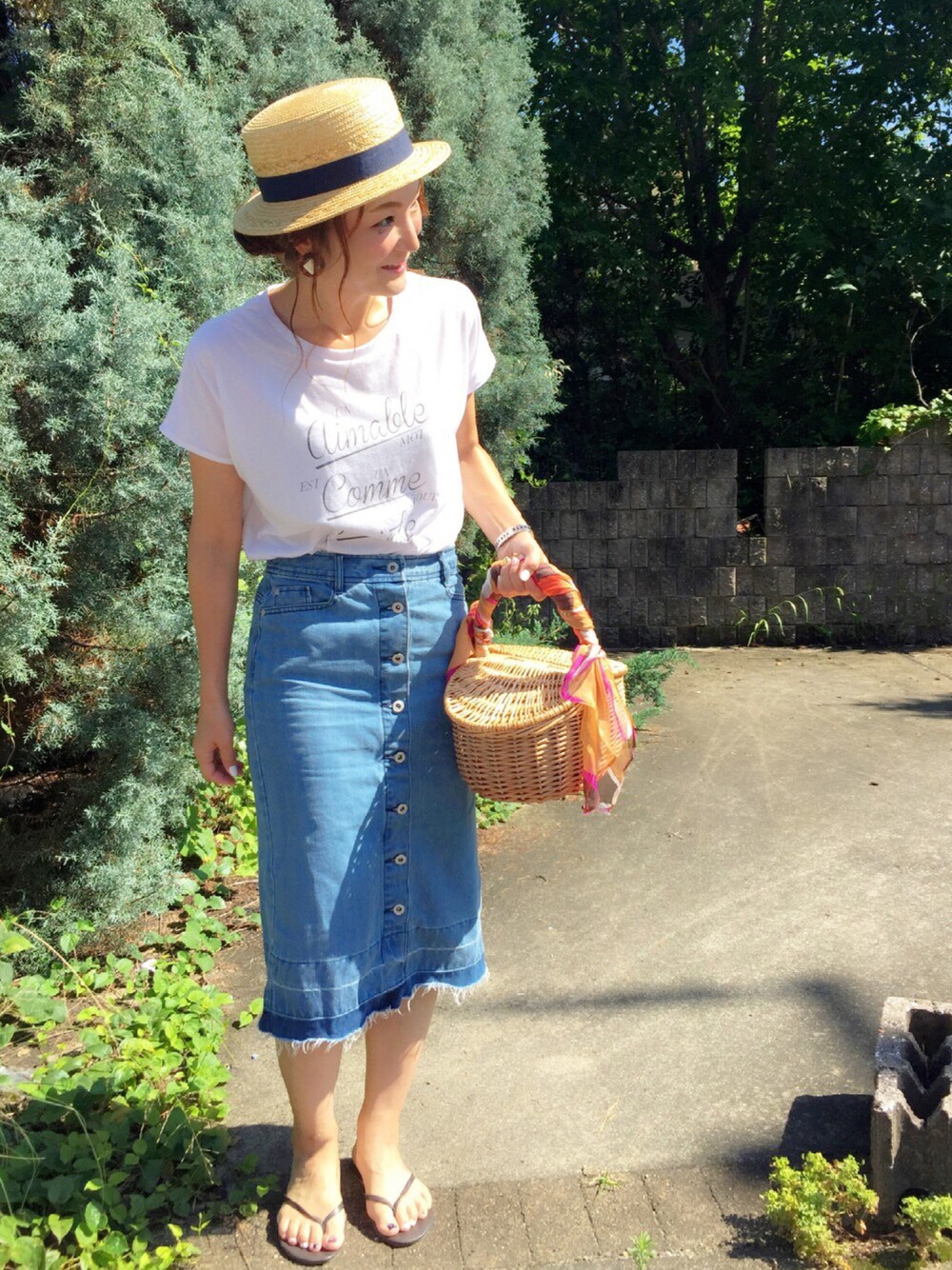 ホワイト系のTシャツ/カットソー、ブルー系のデニムスカート、ベージュ系のハットを着用したレディースの夏コーディネートの1枚目の写真