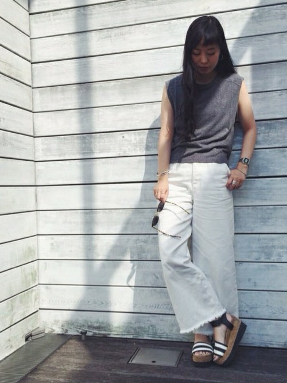 ホワイト系のデニムパンツ、ブルー系のサンダルを着用したレディースの夏コーディネートの1枚目の写真