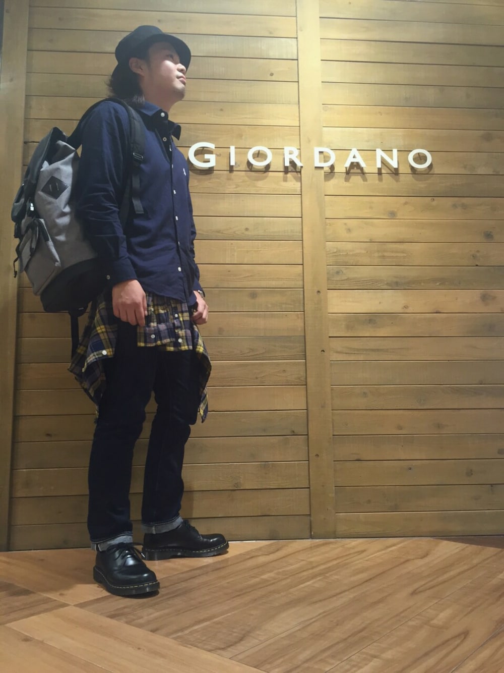 ブルー系のシャツ/ブラウス、イエロー系のトップス、グレー系のバックパック/リュックを着用したメンズの秋コーディネートの1枚目の写真